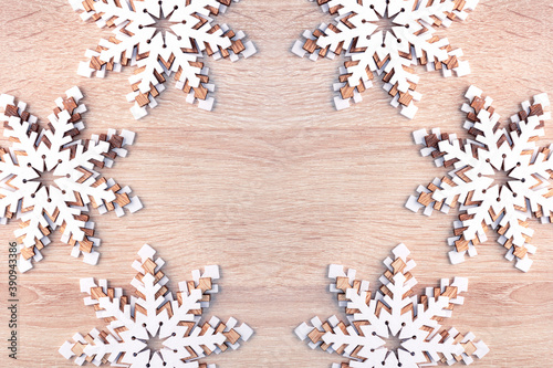 Christmas New Year background with white snowflakes on wooden surface with copy space.