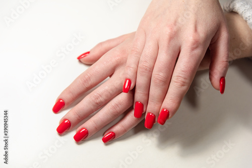 hands of a young girl with red manicure