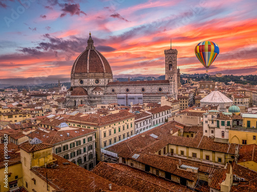 Aerial view of Firenze Florence downtown with colorful medieval houses, the magnificent cathedral, colorful sunset sky with hot air balloon flying by photo