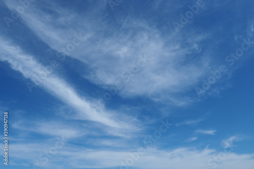 White translucent clouds against a blue sky. Abstract background.