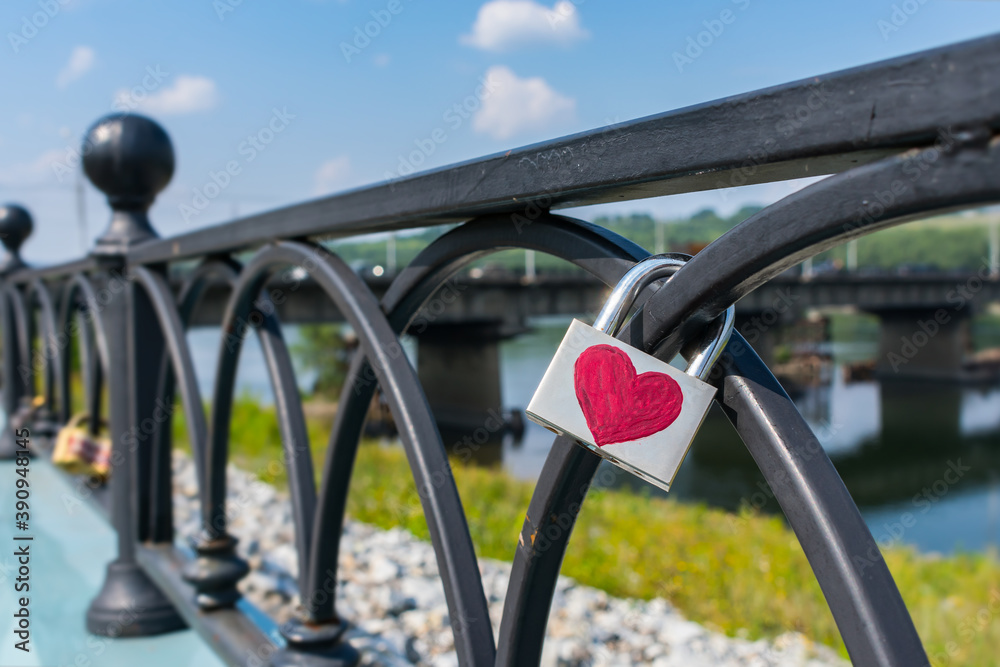 Padlock weighs on the railing of the pavement, hung on Valentine's Day