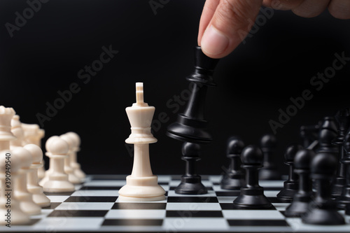 hand businessman moving chess on a chessboard
