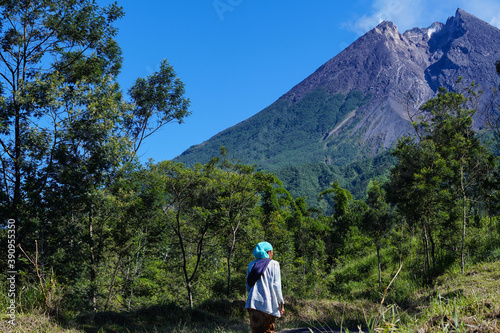 A woman is looking at Mount Merapi photo