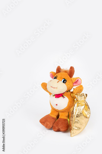 Children's soft toy bull with a bag of gifts, isolate on a white background. Cute toy for children's games. Symbol of the new year 2021. Copy space