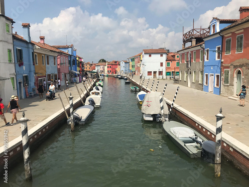 Burano island canal and colorful houses with boats in Venice Italy © April Wong