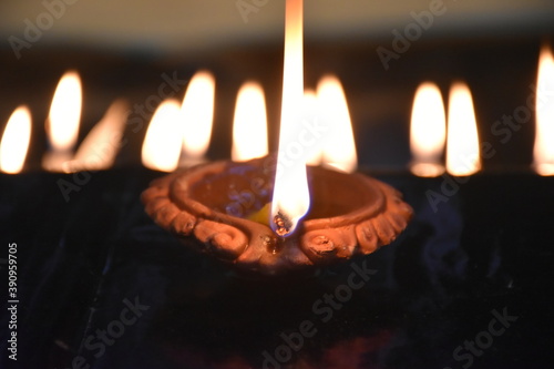 Clay Diya or Oil Lamp lits during the Diwali night. Traditional Diyas lit on gold and black background
