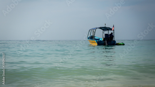 A beautiful view of a speed boat for tourist on blue sea at Perhentian Island, Malaysia. Calm and tranquil environment. Tropical ocean for travel. Selective focused on foreground. Small waves.