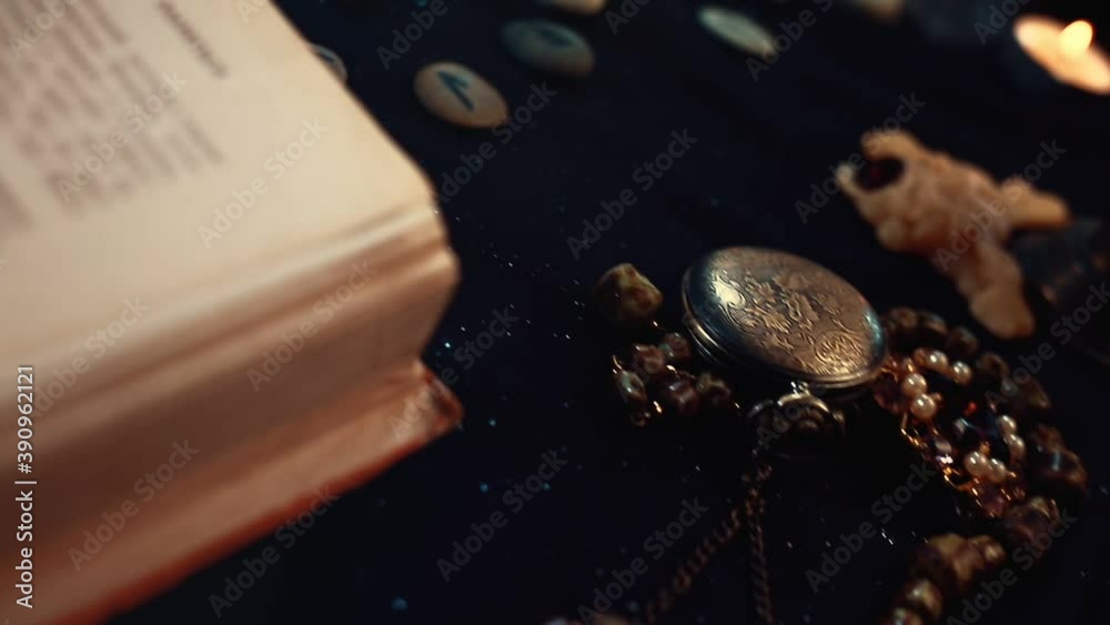 Divination and magic. Camera movement on a table with jewels, a book, runes and a map. Close-up of the fortune-teller's goods Divination and magic. Camera movement on a table with jewels, a book, runes and a map. Close-up of the fortune-teller's goods