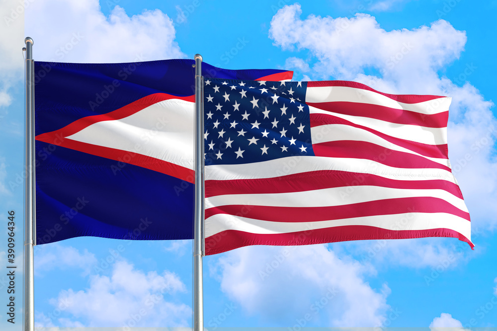 United States and American Samoa national flag waving in the windy deep blue sky. Diplomacy and international relations concept.
