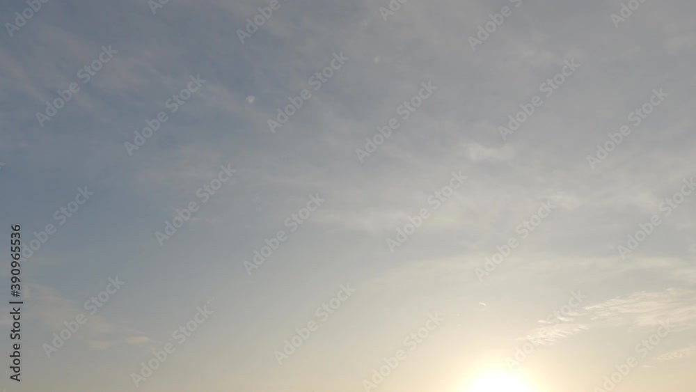 Beautiful pastel golden pink morning sunrise cloud & airy cirrus or cirrocumulus cloudscape on sunny clear blue sky in tropical summer sunlight & sun rays at bright daylight horizon, 4k udh TimeLapse