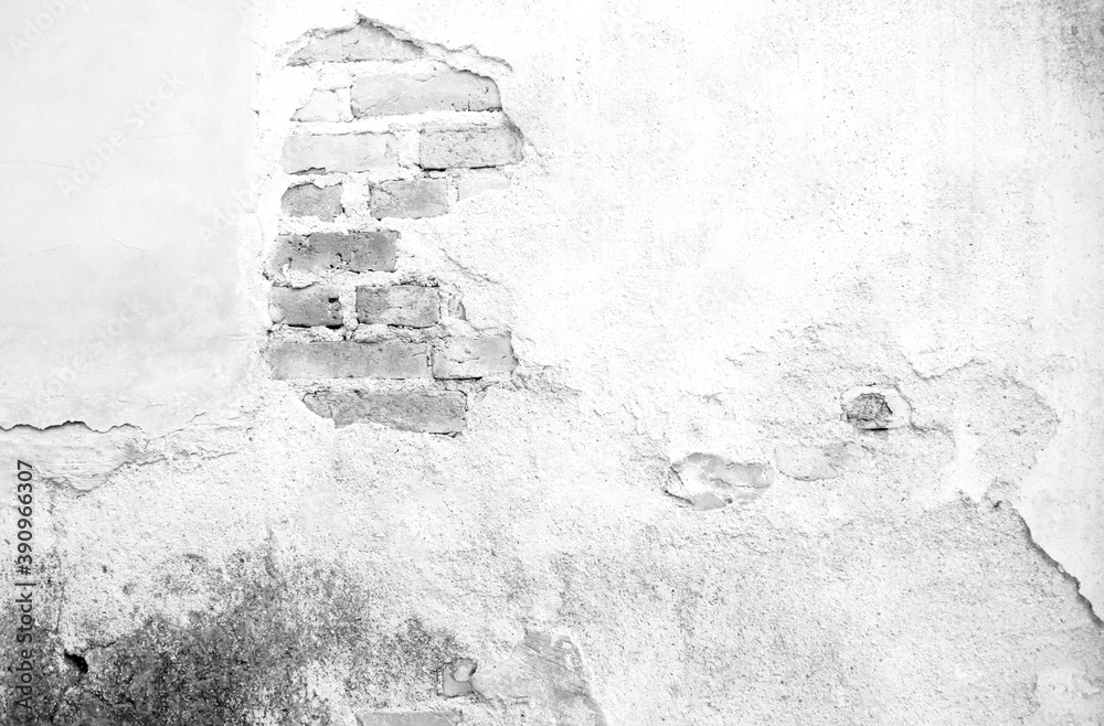 Black and white photo of old masonry, the old stained brick wall cracked and decaying used for background, grunge cracked brick wall for the background. The brick wall is cracking and it's decaying.
