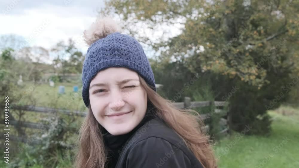 Cute young woman walking in grassy area smiles and winks at the camera (60 fps) Cute young woman walking in grassy area smiles and winks at the camera (60 fps)