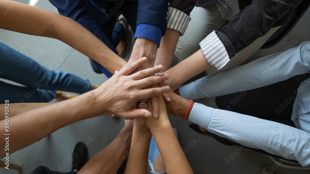 Joining leader. Close up top view of diverse people business partners friends colleagues stacking palms in pile as symbol of racial and gender equality, unity, support of good proposal project startup Joining leader. Close up top view of diverse people business partners friends colleagues stacking palms in pile as symbol of racial and gender equality, unity, support of good proposal project startup