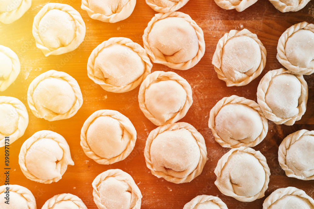 pile of small homemade uncooked dumplings with meat on kitchen table. national traditional Russian cuisine. do it yourself. top view, flat lay pile of small homemade uncooked dumplings with meat on kitchen table. national traditional Russian cuisine. do it yourself. top view, flat lay