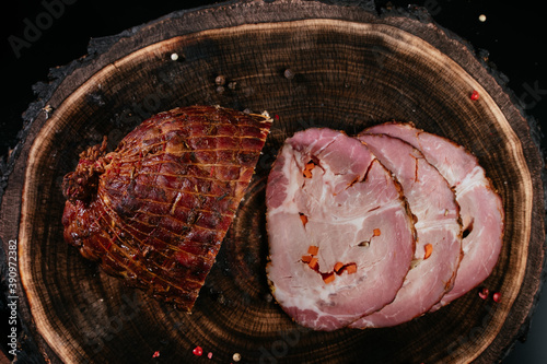 Smoked lard, bacon, half a piece, on a wooden dark craft background. Top view, close-up.