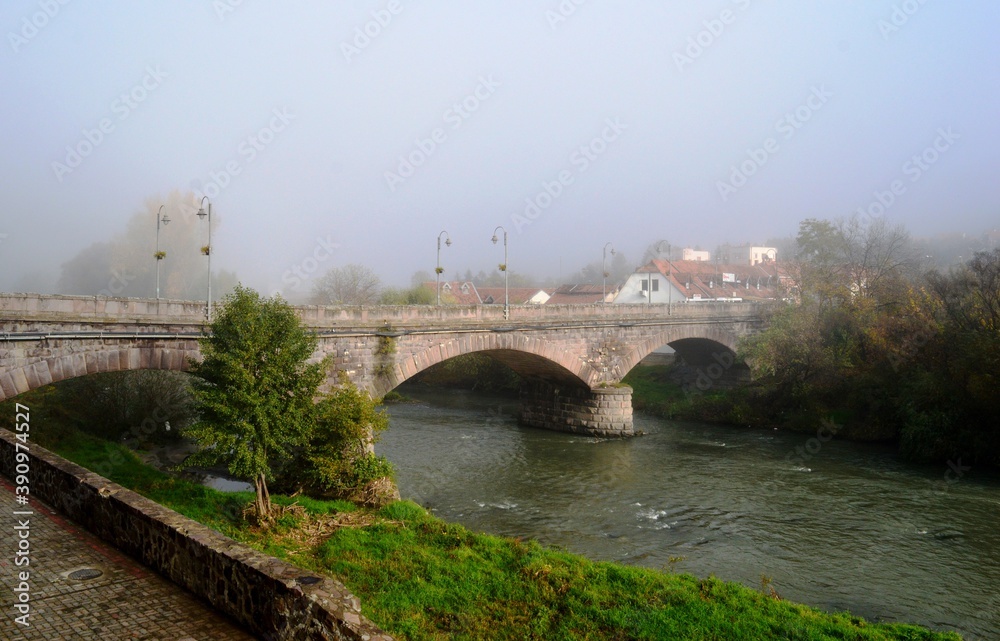an old stone bridge on a foggy morning