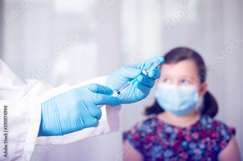 Vaccination concept. Male doctor vaccinating cute little girl in clinic.