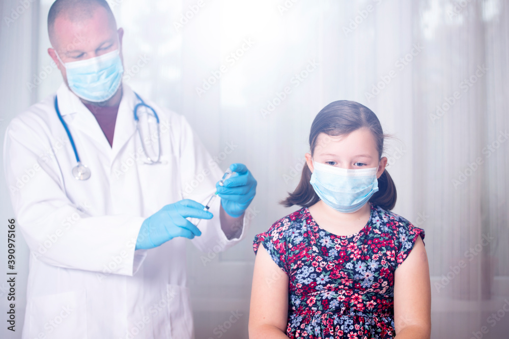Vaccination concept. Male doctor vaccinating cute little girl in clinic.