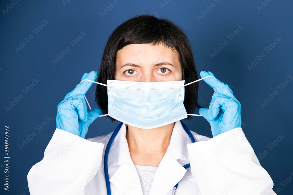 Woman doctor shows how to put on a protective mask. Woman doctor shows how to put on a protective mask.