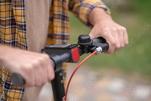 Close up picture of males hands holding scooter handlebar