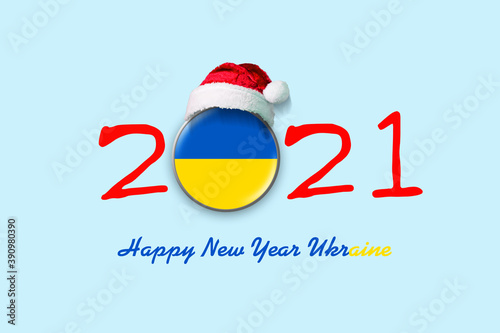 2021. Happy New Year Ukraine. Flag of Ukraine in a round badge, and in a Santa hat. Isolated on a light blue background. Design element.