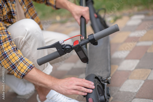 Close up picture of a man fixing his scooter