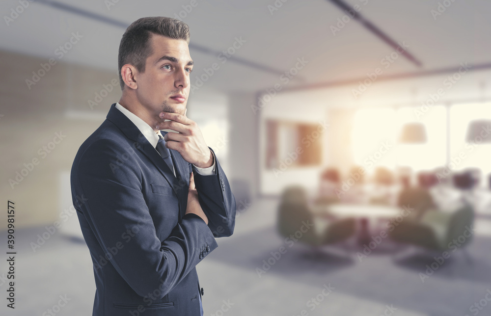 Thoughtful young businessman in office, side view Thoughtful young businessman in office, side view