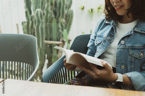 young woman reading book in cafe photo