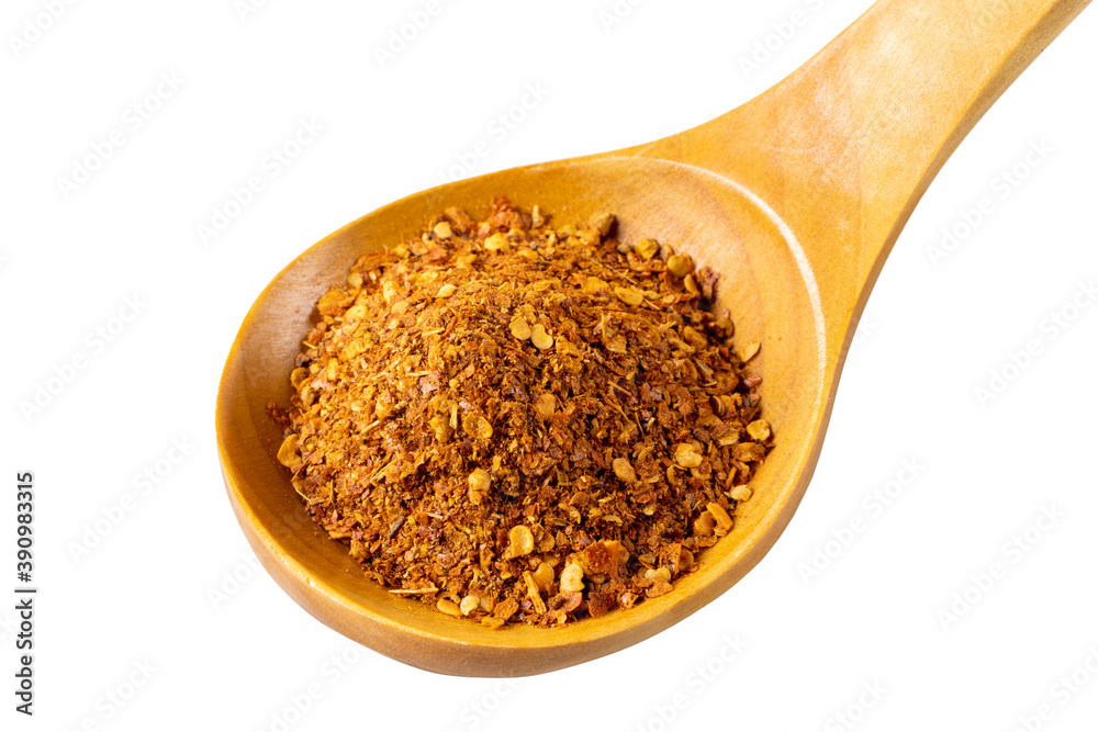 Thai red chili seasoning lies in a lacquered wooden spoon. Isolated on white background. Close-up. Thai red chili seasoning lies in a lacquered wooden spoon. Isolated on white background. Close-up.