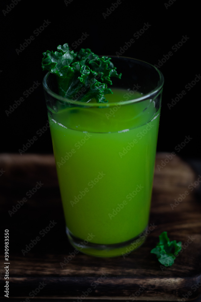 Green drink in a glass with kale on a wooden dark background. Green drink in a glass with kale on a wooden dark background.