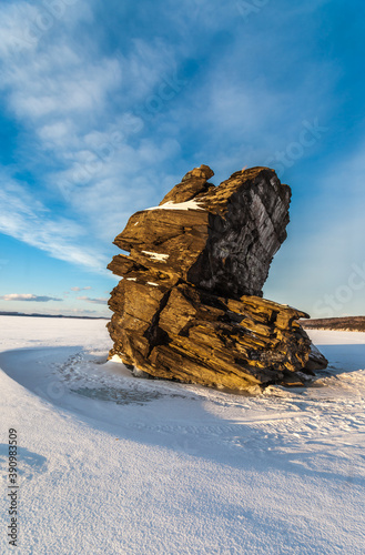 The stone on the frozen lake in winter