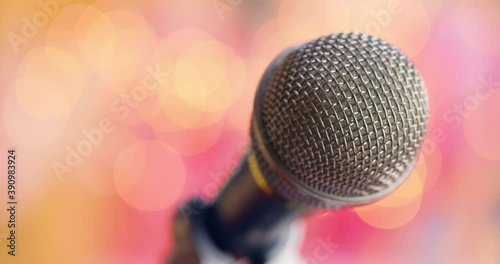 Microphone on stage against a blurry light ,blurry background.