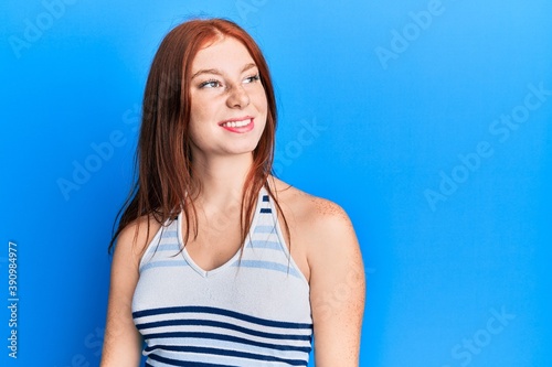 Young red head girl wearing casual clothes looking to side, relax profile pose with natural face and confident smile. © Krakenimages.com