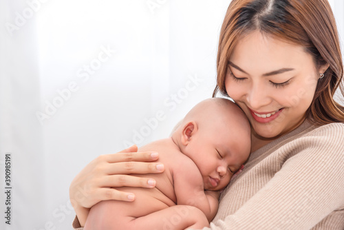 Close up beautiful young asian mother holding her newborn one month baby sleep on her lap. Healthcare and medical.  Lovely asian woman lifestyle mother's day concept.