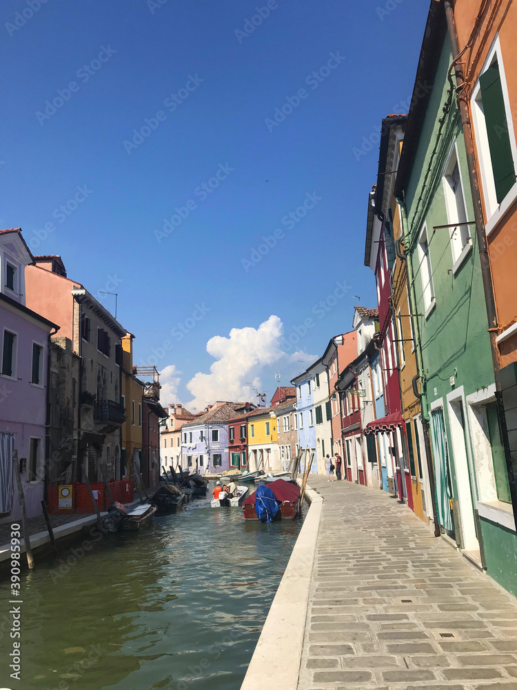 Fototapeta Burano island canal and colorful houses with boats in Venice Italy