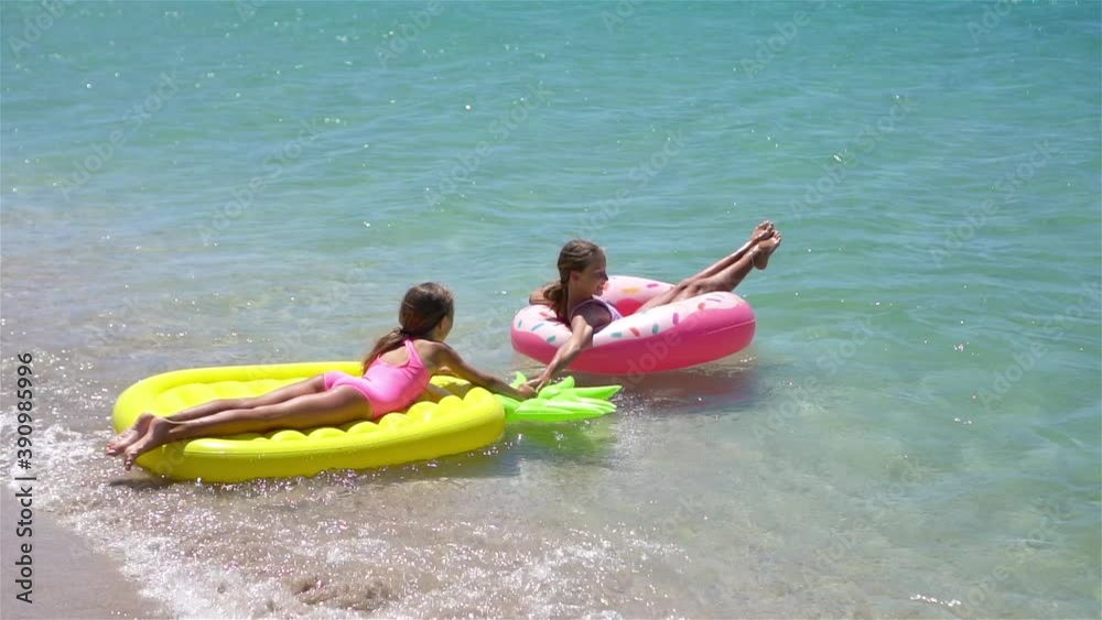 Little girls having fun at tropical beach during summer vacation playing together Little girls having fun at tropical beach during summer vacation playing together