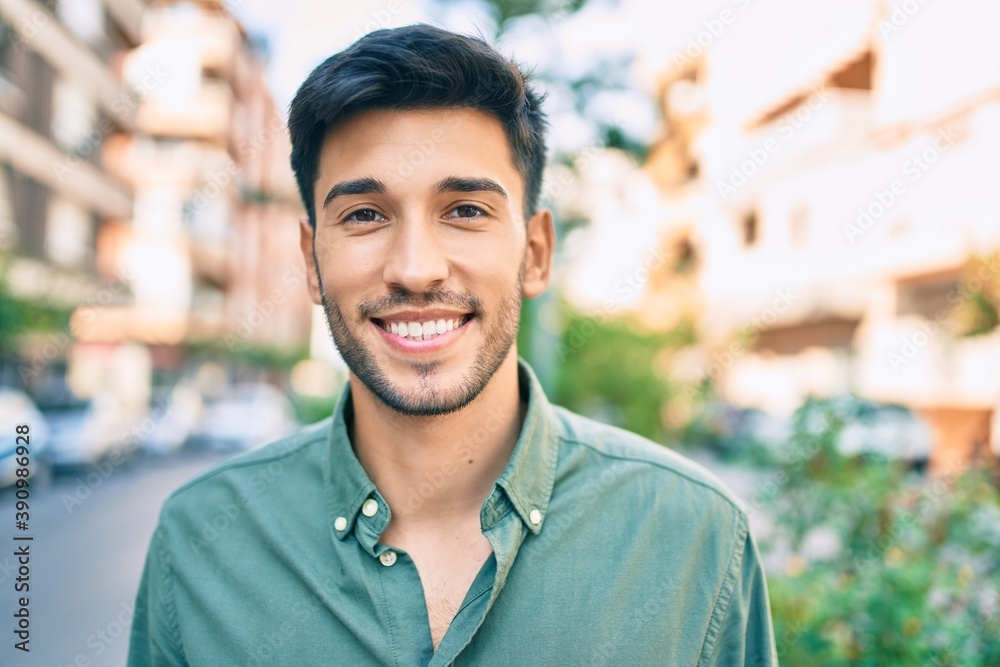 Young latin man smiling happy walking at the city. Young latin man smiling happy walking at the city.