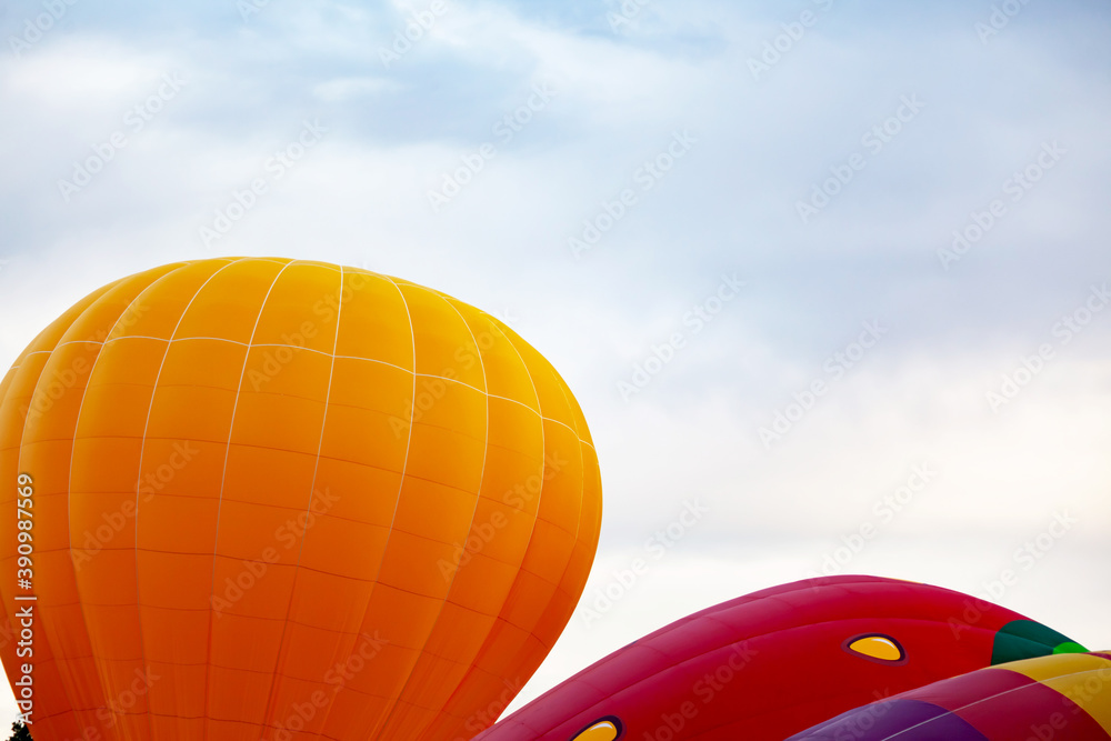 Obraz premium two balloons of orange and red against the cloudy sky
