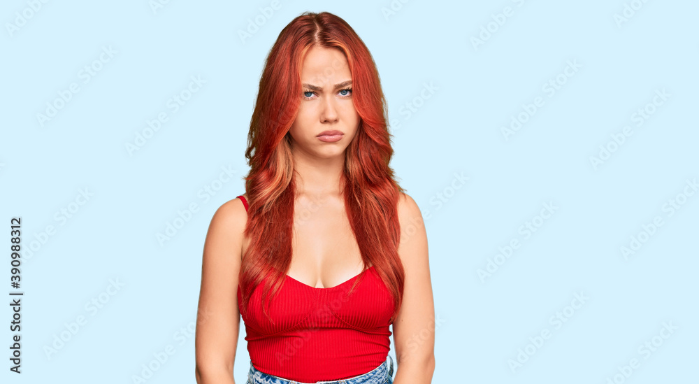 Young redhead woman wearing casual clothes skeptic and nervous, frowning upset because of problem. negative person. Young redhead woman wearing casual clothes skeptic and nervous, frowning upset because of problem. negative person.