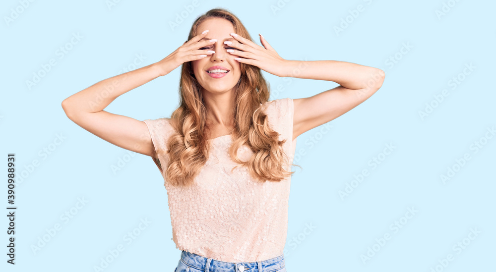 Young beautiful caucasian woman with blond hair wearing casual clothes covering eyes with hands smiling cheerful and funny. blind concept. Young beautiful caucasian woman with blond hair wearing casual clothes covering eyes with hands smiling cheerful and funny. blind concept.