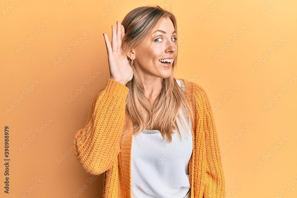 Beautiful caucasian woman wearing casual clothes smiling with hand over ear listening and hearing to rumor or gossip. deafness concept. Beautiful caucasian woman wearing casual clothes smiling with hand over ear listening and hearing to rumor or gossip. deafness concept.