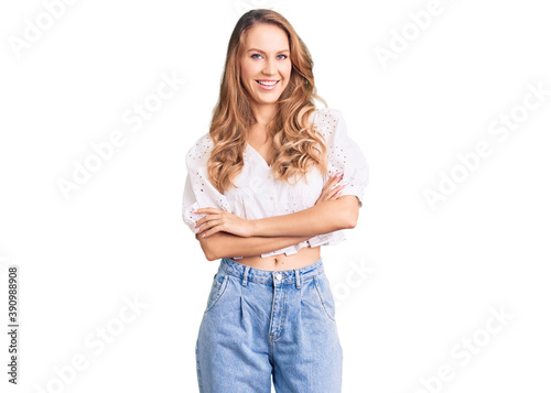 Young caucasian woman with blond hair wearing elegant summer tshirt happy face smiling with crossed arms looking at the camera. positive person.