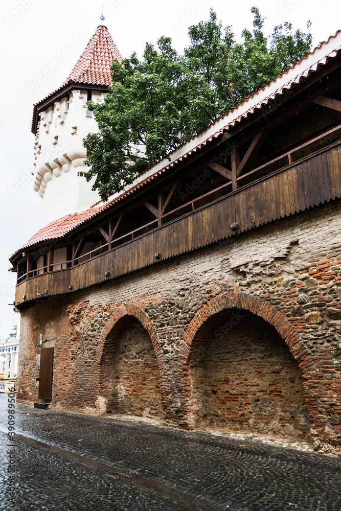 Fototapeta premium Cetatii Street with the Carpenters Tower and a wooden covered gallery that connects with the Potters Tower. Sibiu, Romania.
