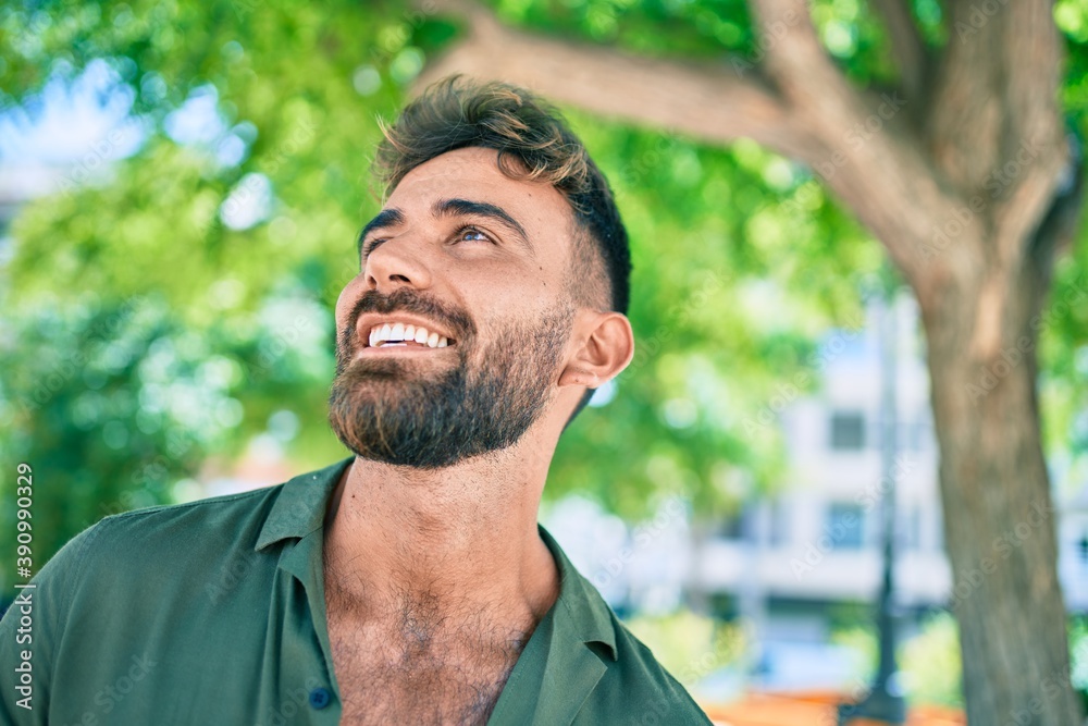 Fototapeta premium Young hispanic man smiling happy walking at the park