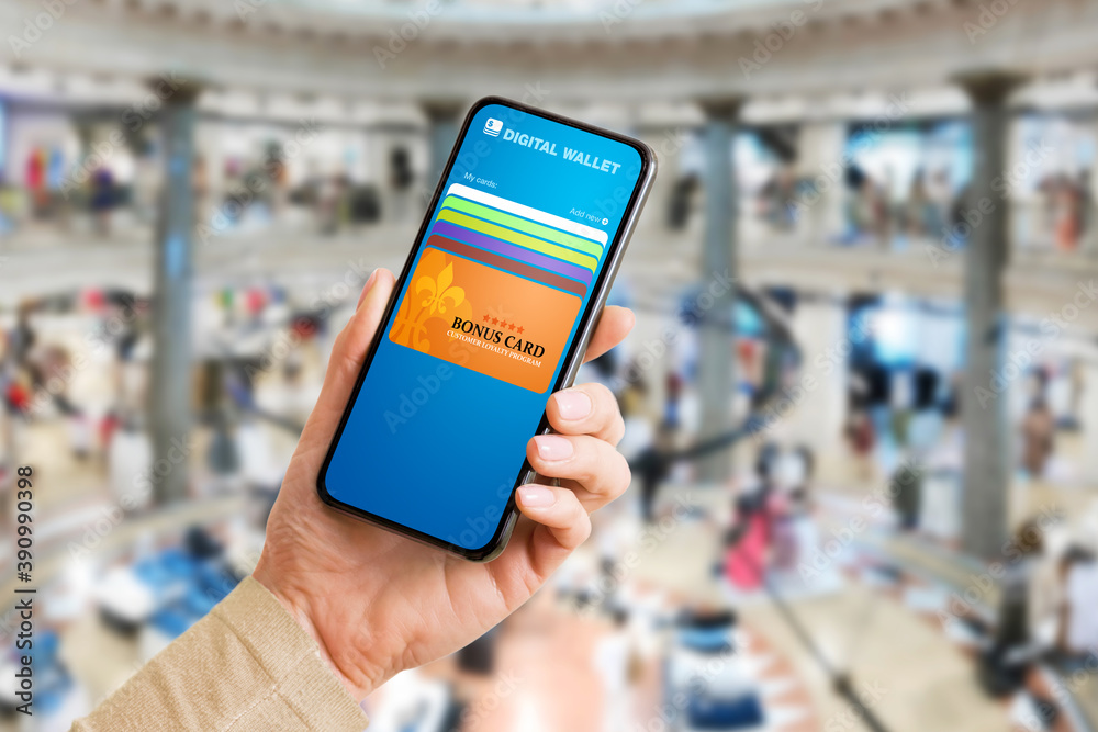 Person in shopping mall using mobile app on phone with bonus and customer loyalty  program cards for discounts or special offers. Photos | Adobe Stock