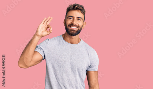 Young hispanic man wearing casual clothes smiling positive doing ok sign with hand and fingers. successful expression. © Krakenimages.com