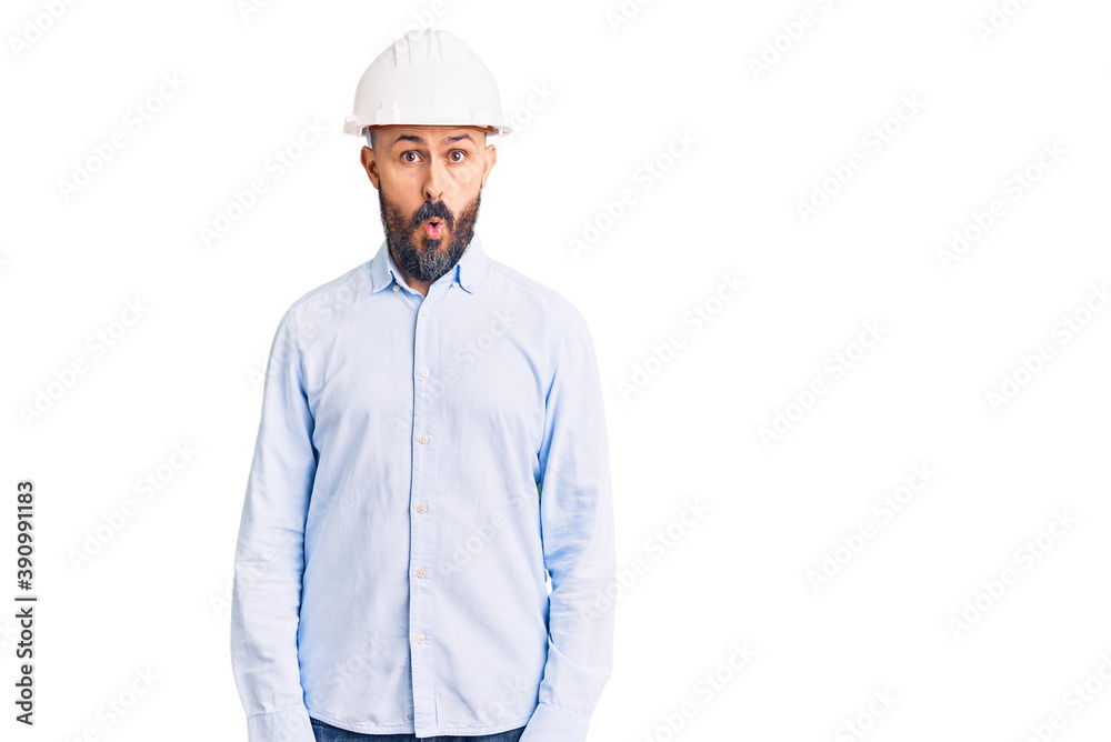 Young handsome man wearing architect hardhat afraid and shocked with surprise expression, fear and excited face. Young handsome man wearing architect hardhat afraid and shocked with surprise expression, fear and excited face.
