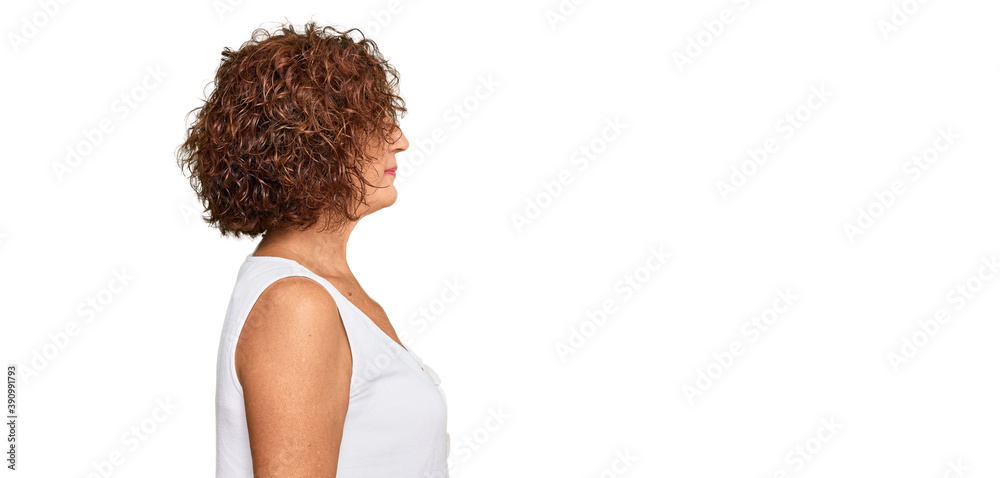 Beautiful middle age mature woman wearing casual white shirt looking to side, relax profile pose with natural face with confident smile. Beautiful middle age mature woman wearing casual white shirt looking to side, relax profile pose with natural face with confident smile.
