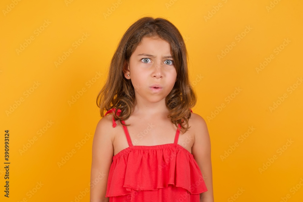 young Caucasian girl standing against yellow background expressing disgust, unwillingness, disregard having tensive look frowning face, looking indignant with something. young Caucasian girl standing against yellow background expressing disgust, unwillingness, disregard having tensive look frowning face, looking indignant with something.
