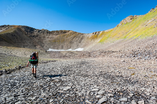 Male Hiker in dry mountain terrain. Young man alone trekking and backpacking near Sary Chelek lake, Sary-Chelek Jalal Abad region, Kyrgyzstan, Trekking in Central Asia.